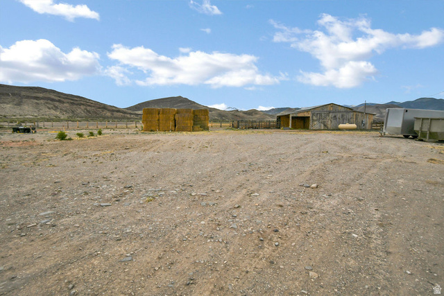 544 East 600 North, Unit 1 Joseph, UT 84739 - Photo 53 of 65 Expansive gravel lot featuring a large barn, visible fencing, and mountainous terrain in the background