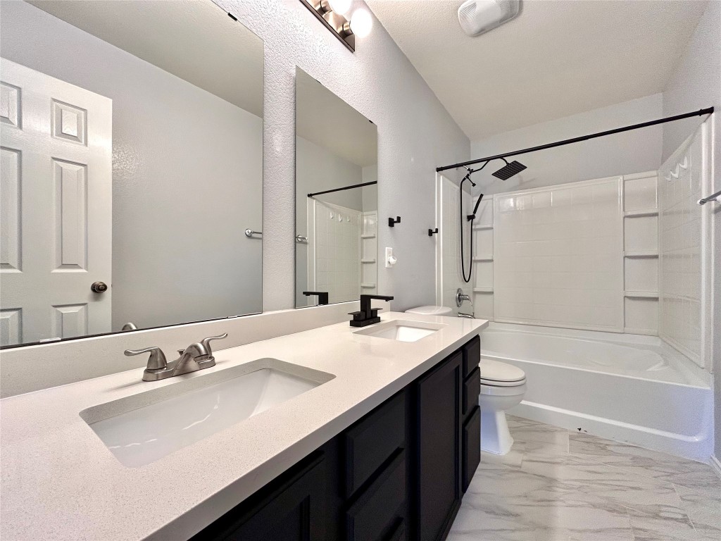 2011 Ashberry Trail Georgetown, TX 78626 - Photo 11 of 24 Full bathroom with double vanity, shower combination, and light marble finish flooring