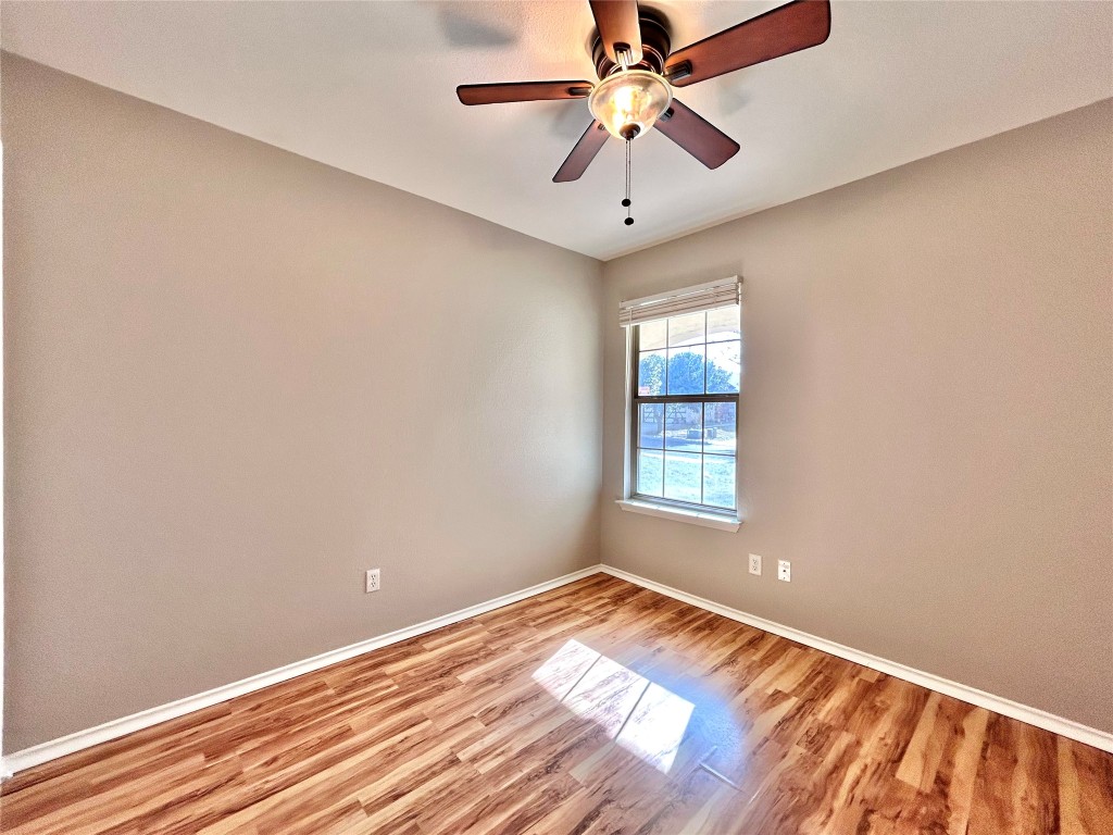 2011 Ashberry Trail Georgetown, TX 78626 - Photo 13 of 24 Unfurnished room with wood finished floors and a ceiling fan