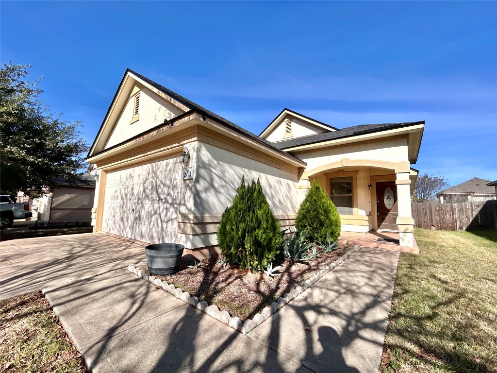 2011 Ashberry Trail Georgetown, TX 78626 - Photo 2 of 24 View of front of house with concrete driveway, an attached garage, and stucco siding