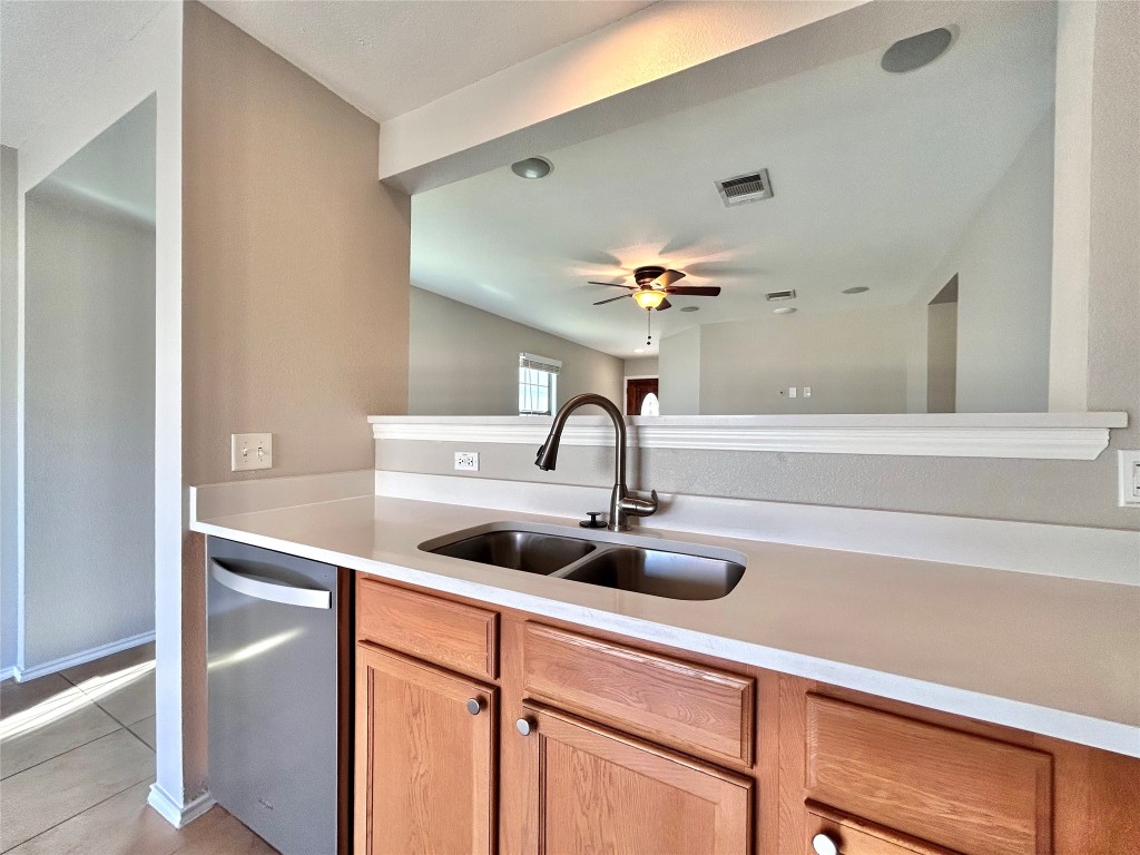 2011 Ashberry Trail Georgetown, TX 78626 - Photo 6 of 24 Kitchen featuring dishwasher, light stone counters, light tile patterned flooring, ceiling fan, and light brown cabinets