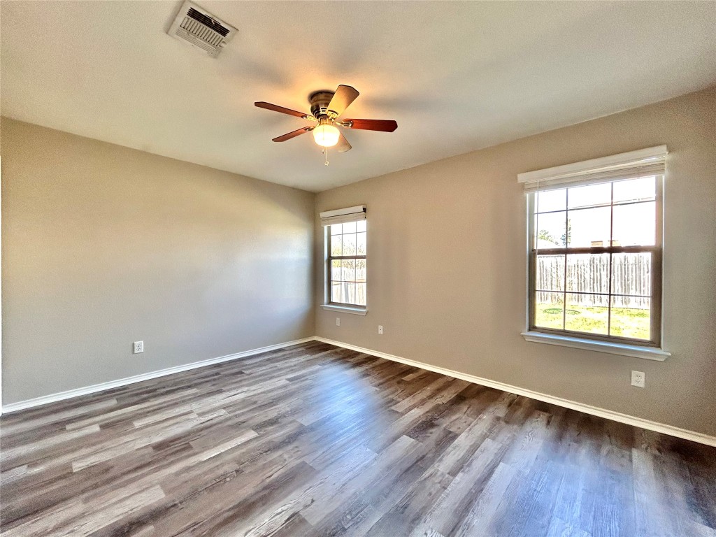 2011 Ashberry Trail Georgetown, TX 78626 - Photo 9 of 24 Empty room with wood finished floors and ceiling fan