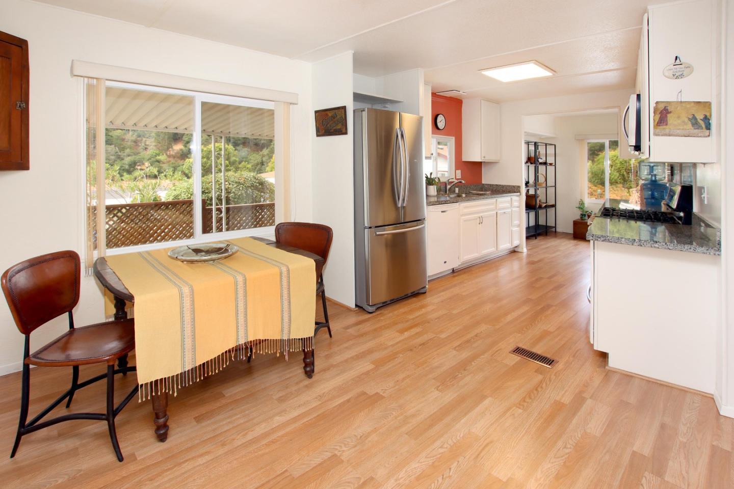 270 Hames Road, Unit 38 Corralitos, CA 95076 - Photo 14 of 35 a kitchen with stainless steel appliances kitchen island granite countertop a refrigerator a stove a sink and white cabinets with wooden floor