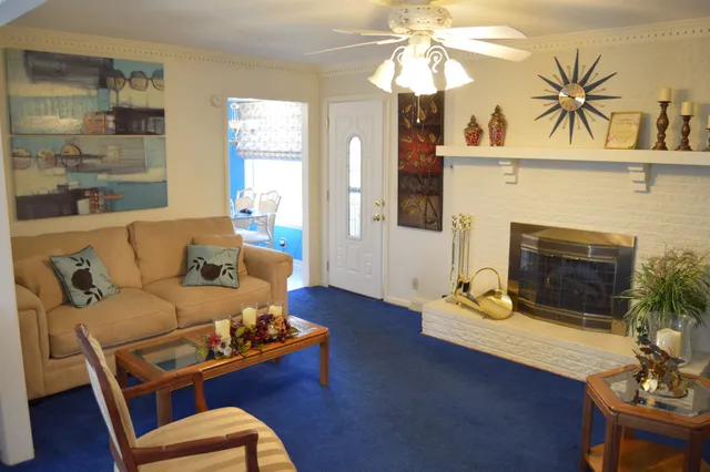 a living room with furniture fireplace and wooden floor