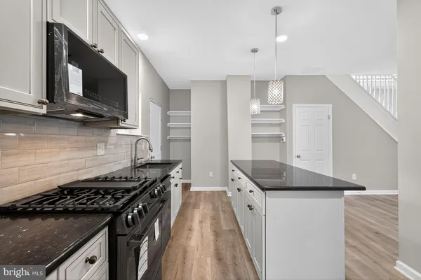 a kitchen with granite countertop stainless steel appliances and wooden cabinets