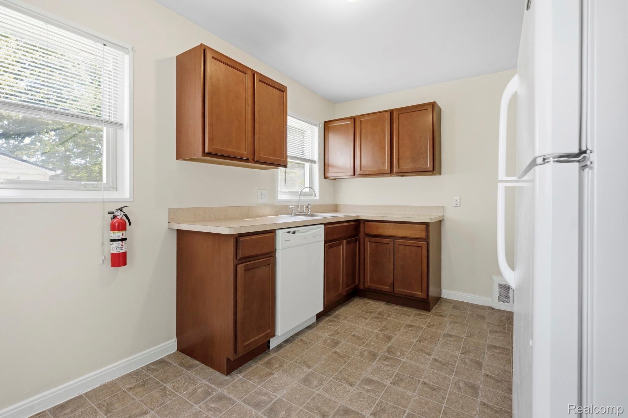 970 Champaign Road Lincoln Park, MI 48146 - Photo 16 of 28 Kitchen with white appliances, light countertops, and wood finish cabinets