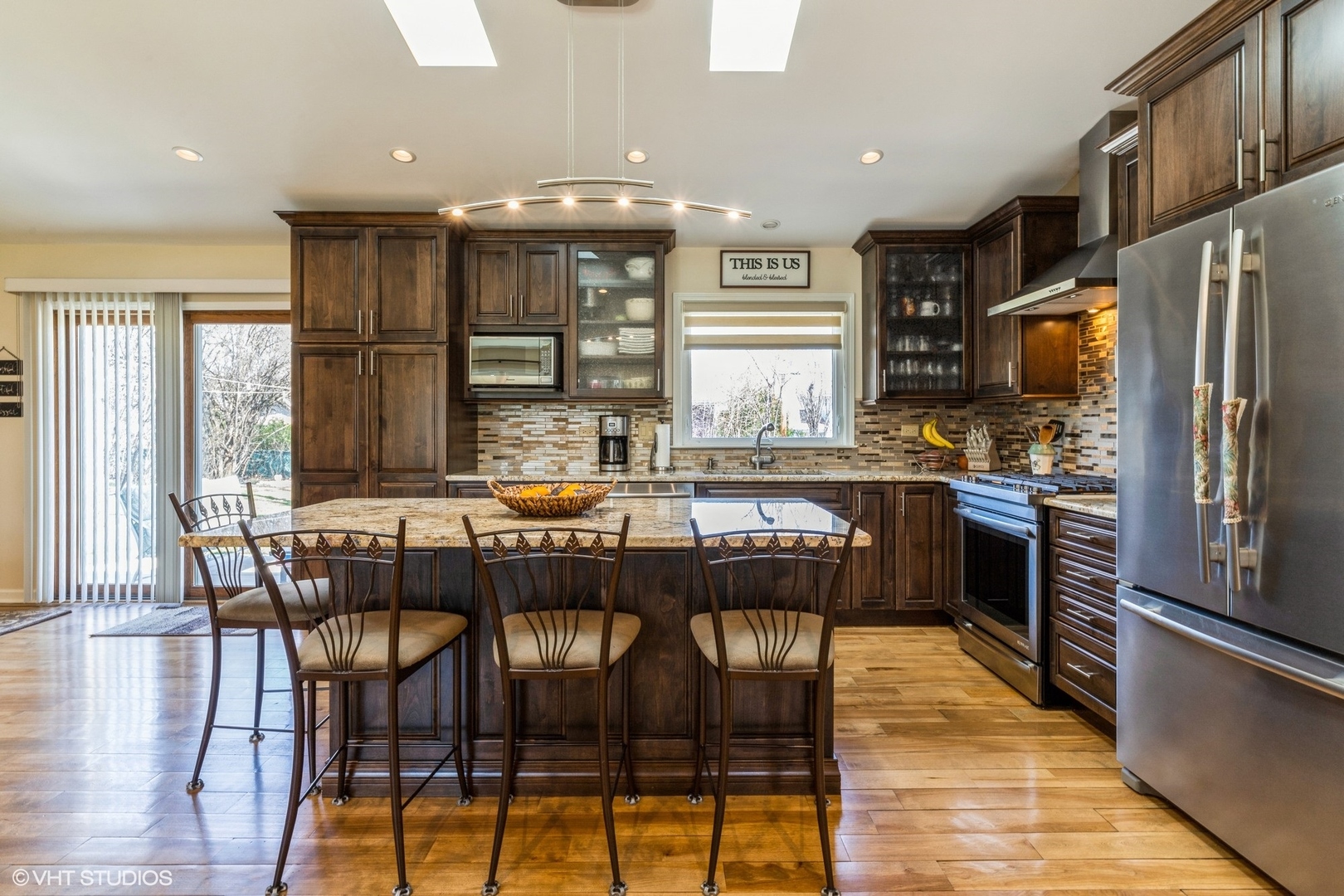 1755 Winthrop Road Highland Park, IL 60035 - Photo 5 of 15 a kitchen with stainless steel appliances granite countertop a stove a refrigerator a kitchen island and chairs in it