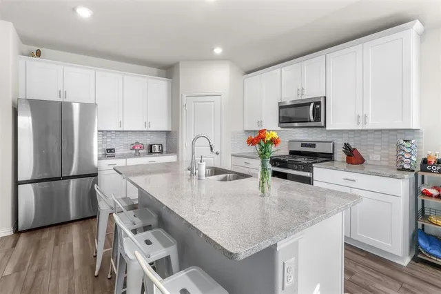 a kitchen with kitchen island a white counter top space cabinets and stainless steel appliances