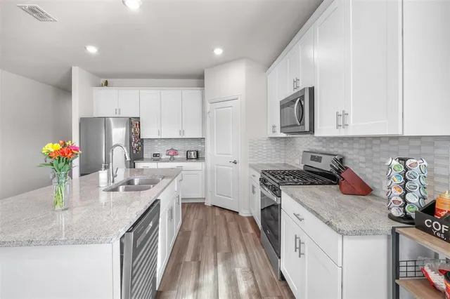 a kitchen with stainless steel appliances granite countertop a sink stove and refrigerator