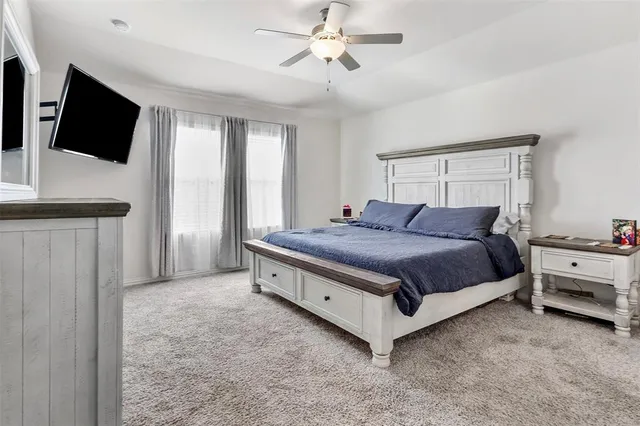 a spacious bedroom with a bed and a flat screen tv