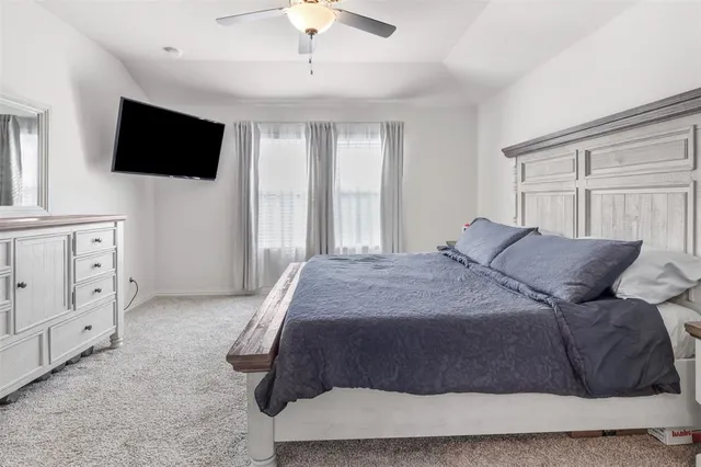 a spacious bedroom with a bed and a flat screen tv