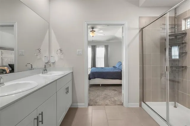 a en suite bathroom with a double vanity sink and a mirror