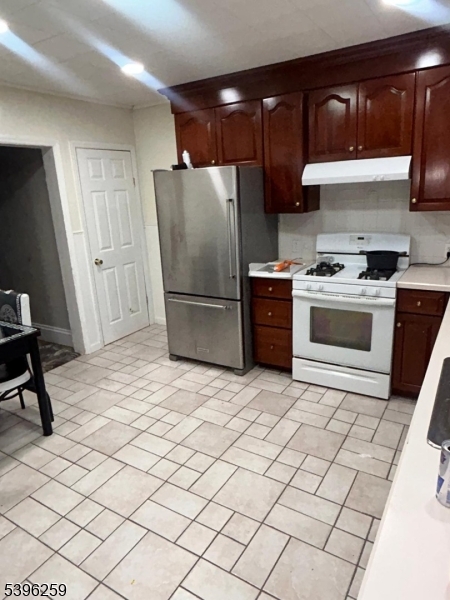 114 Ely Street Elizabeth, NJ 07202 - Photo 3 of 13 a kitchen with a refrigerator and a stove top oven