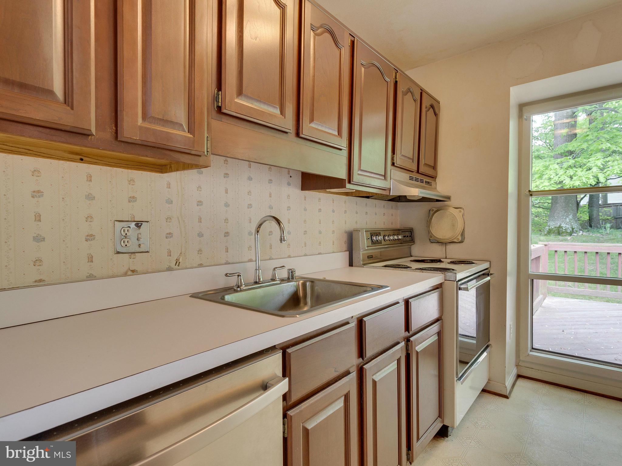 8207 Old Oaks Drive Springfield, VA 22152 - Photo 11 of 30 a kitchen with stainless steel appliances granite countertop a sink and a white cabinets
