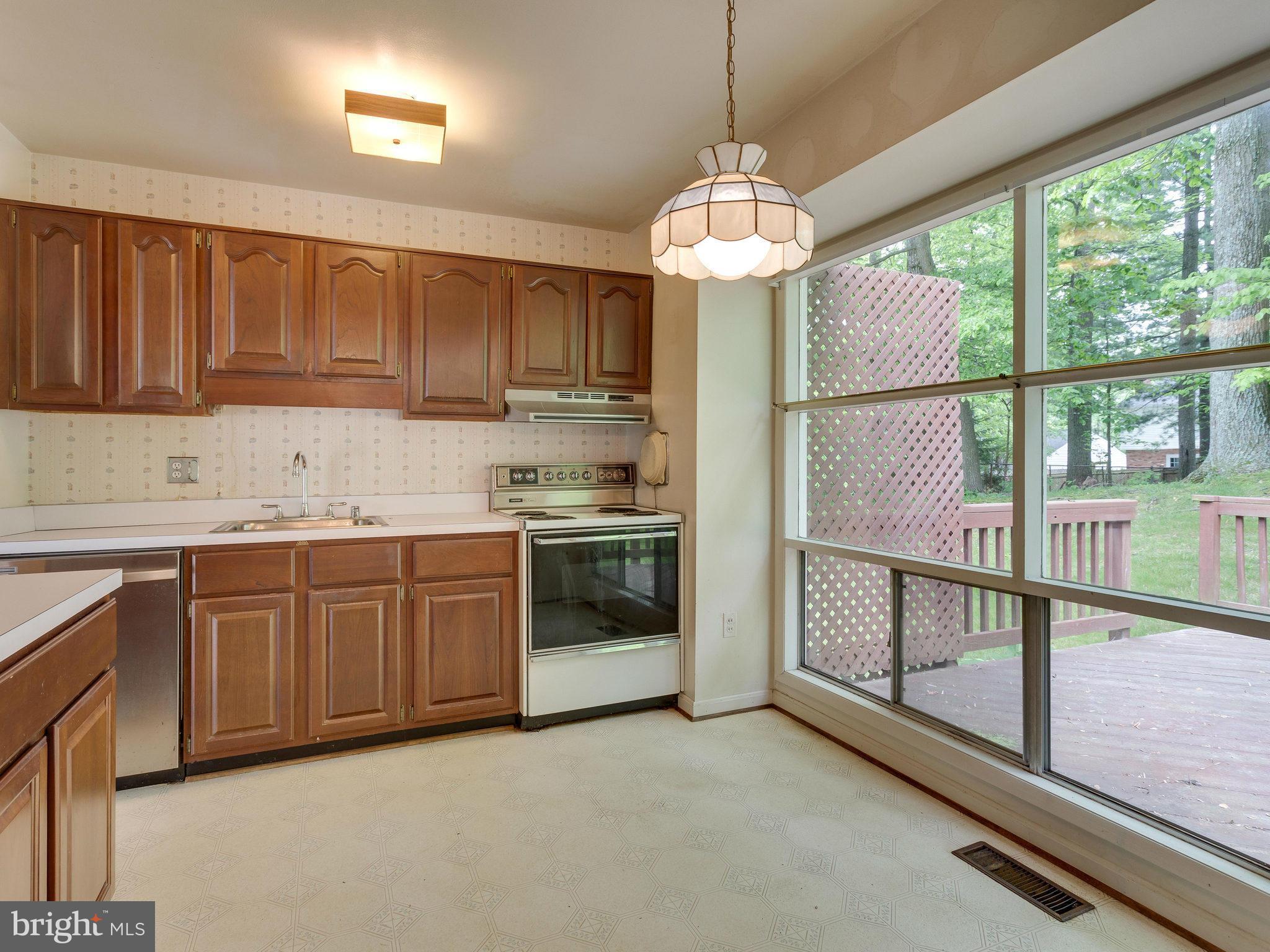 8207 Old Oaks Drive Springfield, VA 22152 - Photo 7 of 30 a kitchen with stainless steel appliances granite countertop a stove sink and cabinets