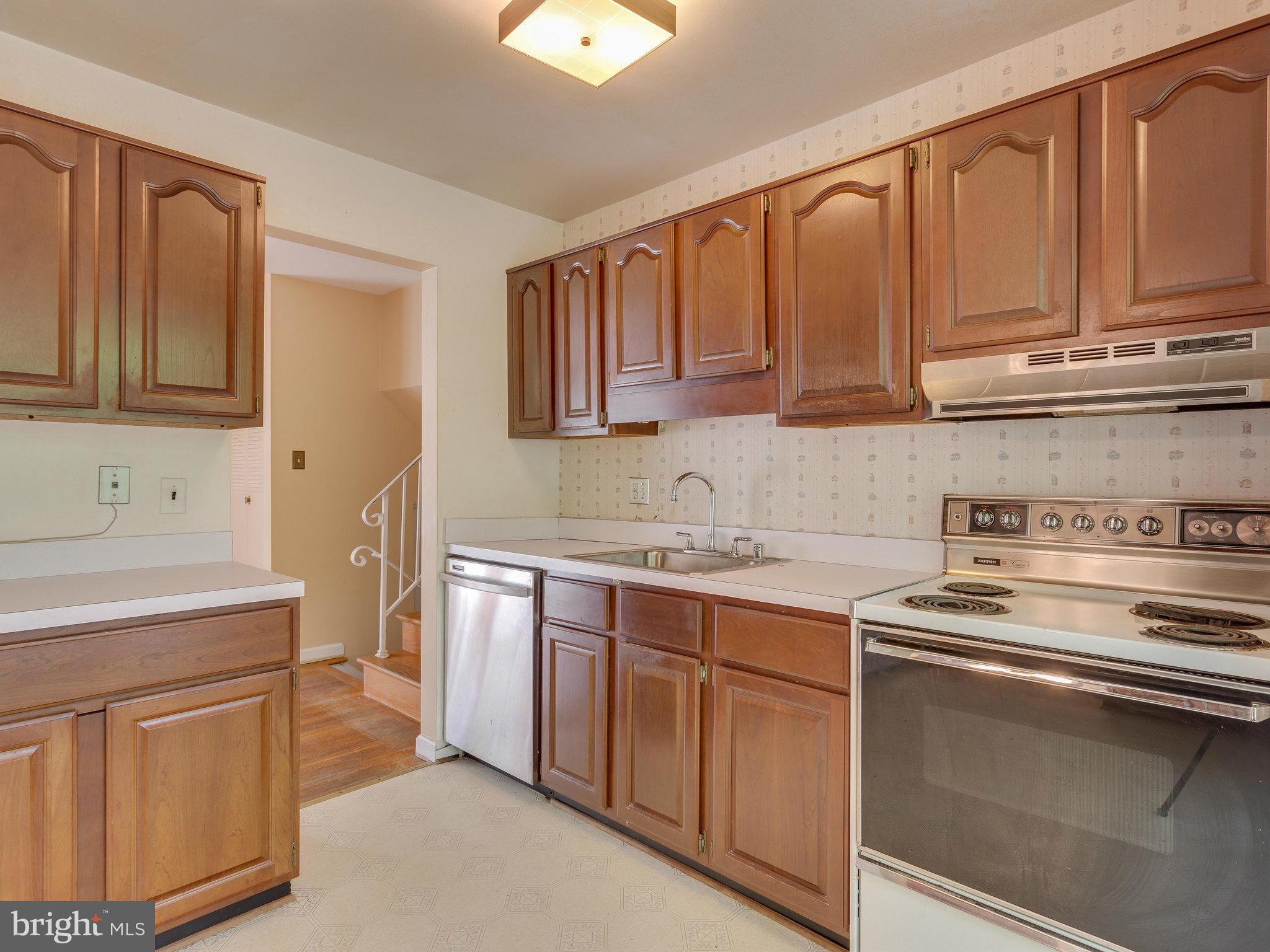 8207 Old Oaks Drive Springfield, VA 22152 - Photo 10 of 30 a kitchen with stainless steel appliances granite countertop a sink stove and cabinets