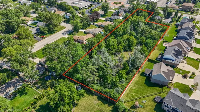 an aerial view of residential house with outdoor space and trees all around