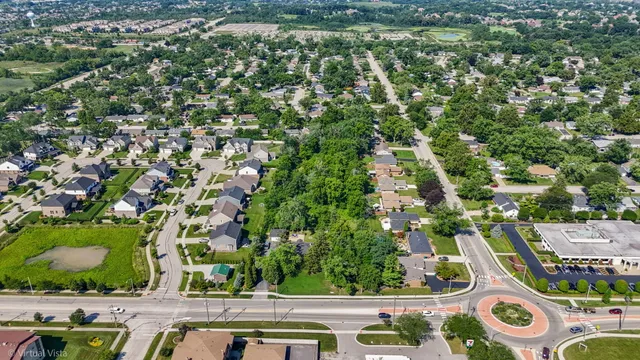 an aerial view of residential houses with outdoor space and trees