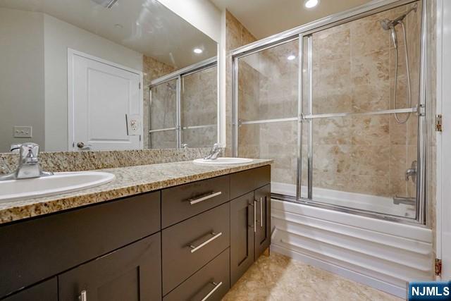 29 1st Street, Unit 401 Hackensack, NJ 07601 - Photo 18 of 26 a bathroom with a granite countertop sink mirror and double