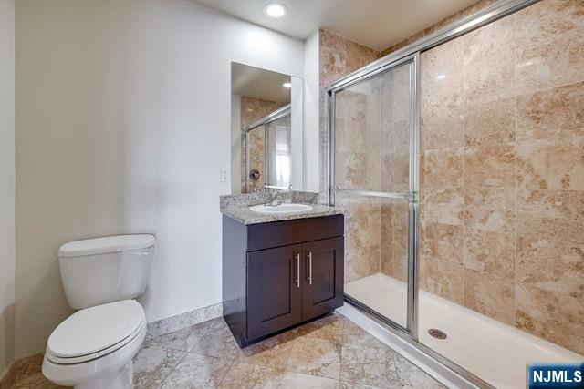 29 1st Street, Unit 401 Hackensack, NJ 07601 - Photo 19 of 26 a bathroom with a toilet a sink and shower