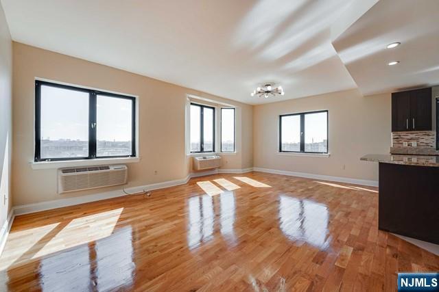 29 1st Street, Unit 401 Hackensack, NJ 07601 - Photo 4 of 26 a view of an empty room with wooden floor and a window
