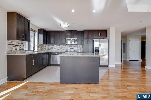 29 1st Street, Unit 401 Hackensack, NJ 07601 - Photo 6 of 26 a kitchen with stainless steel appliances granite countertop a sink counter space and cabinets