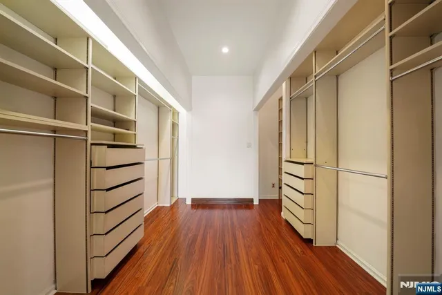 a view of walk in closet with wooden floor