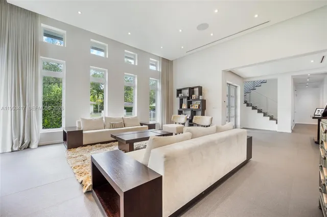 a living room with fireplace furniture and a large window