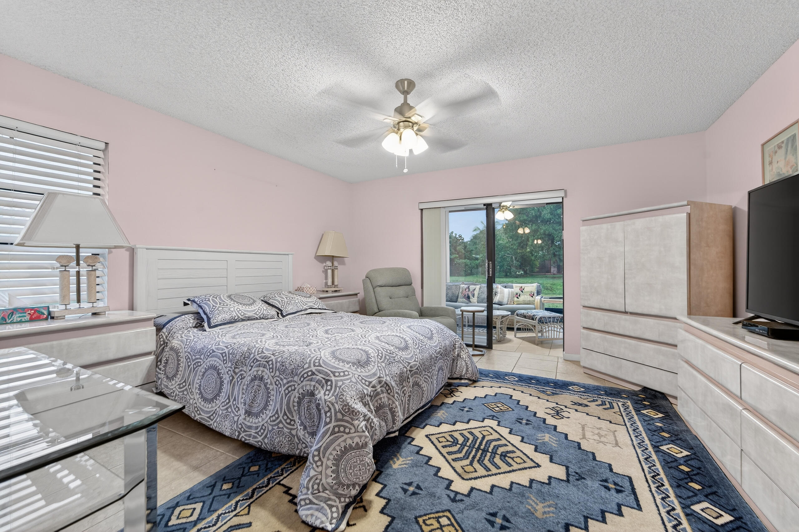 6220 Kings Gate Circle Delray Beach, FL 33484 - Photo 17 of 59 a bedroom with a bed and a flat tv screen on dresser