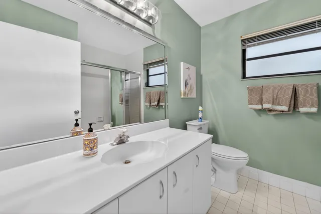 a bathroom with a granite countertop shower a mirror and a sink