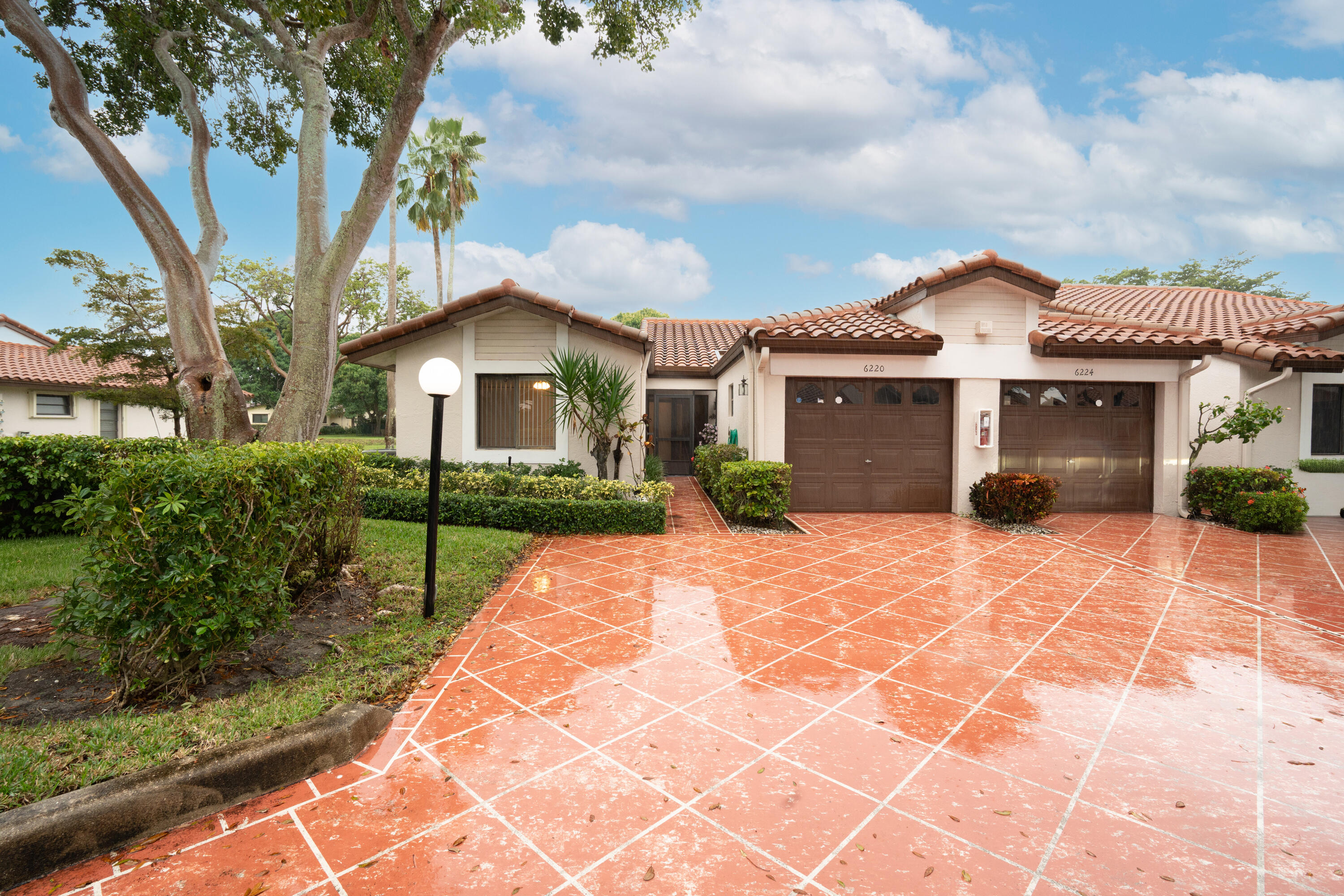 6220 Kings Gate Circle Delray Beach, FL 33484 - Photo 30 of 59 a front view of a house with a garden