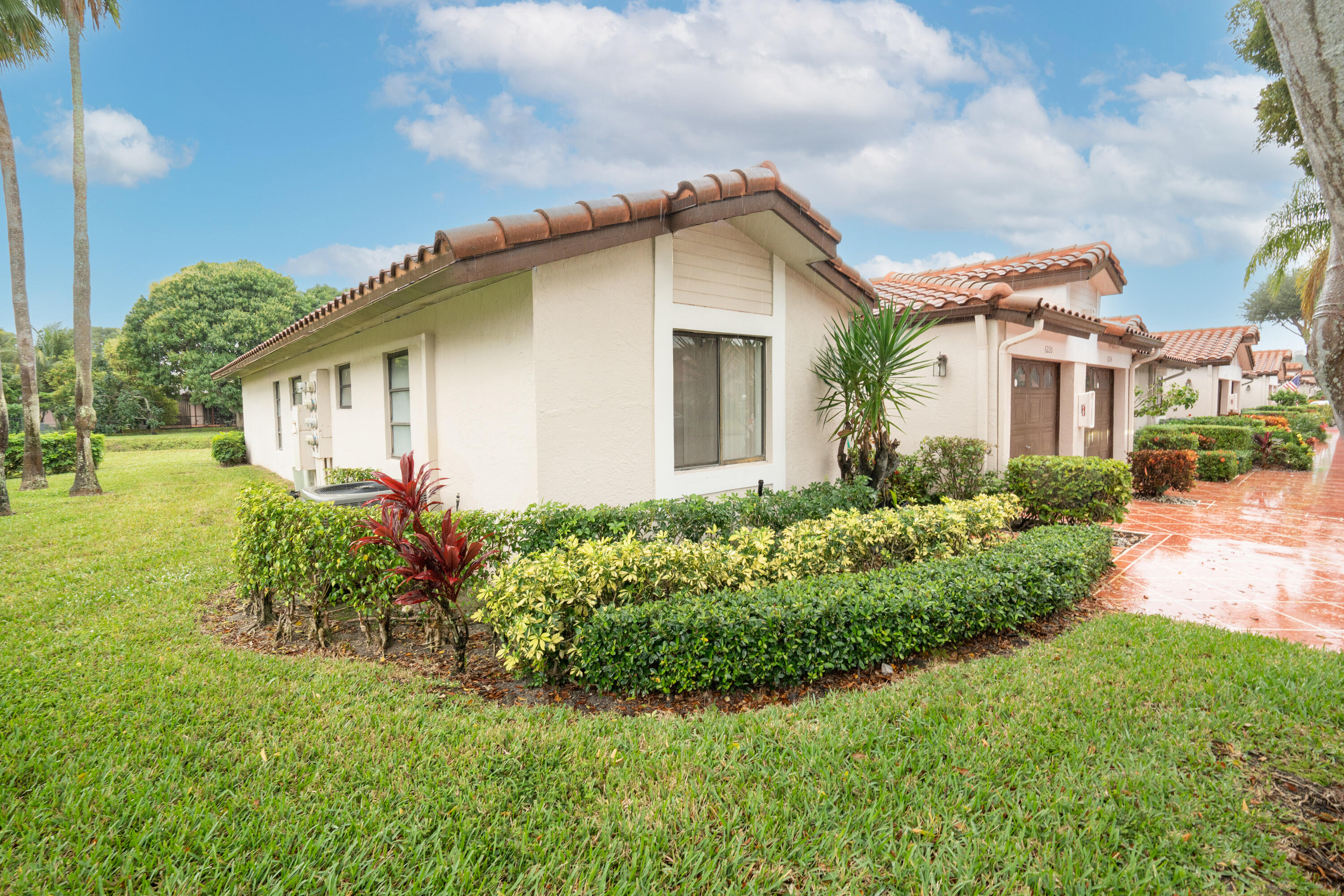 6220 Kings Gate Circle Delray Beach, FL 33484 - Photo 32 of 59 a front view of a house with garden