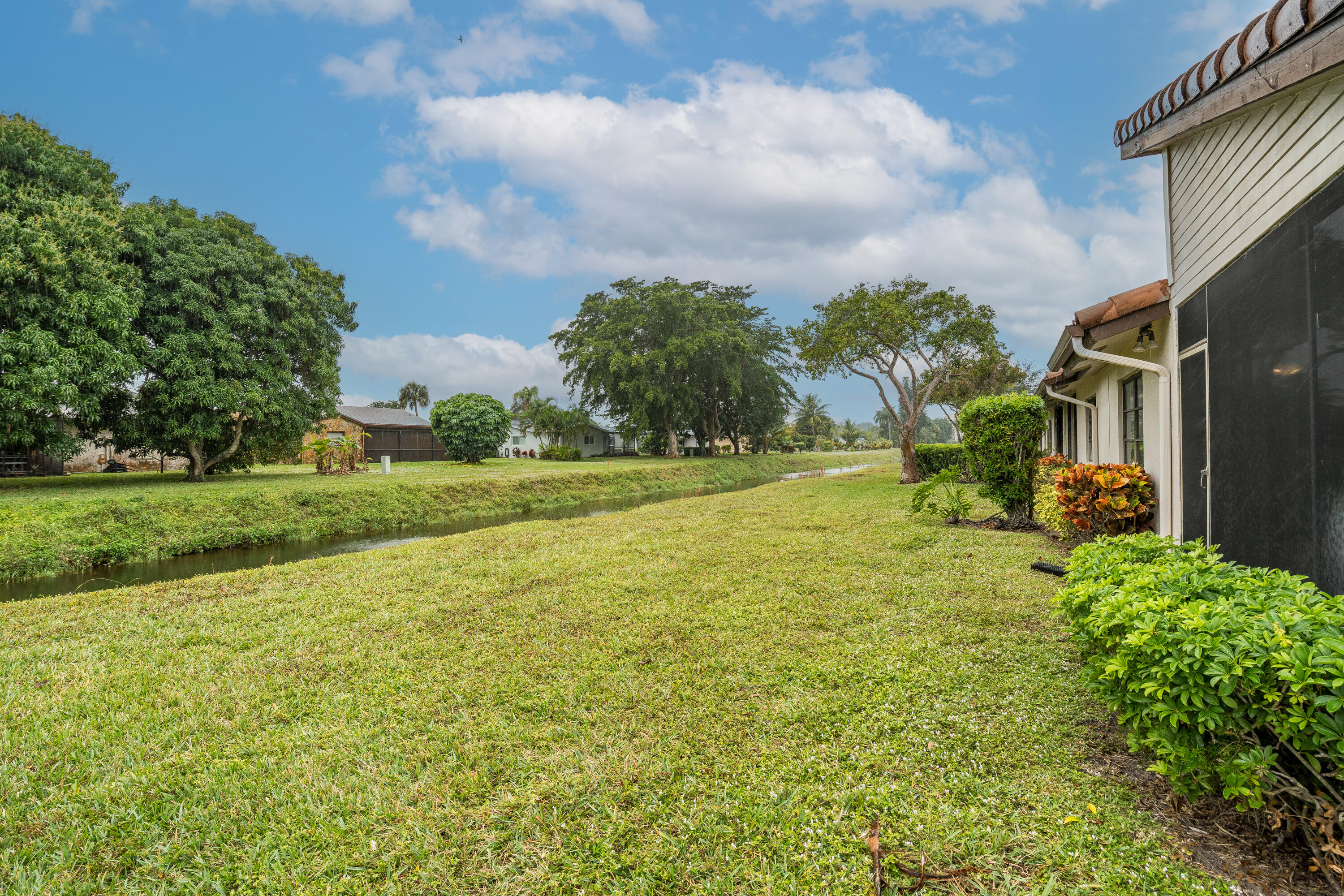6220 Kings Gate Circle Delray Beach, FL 33484 - Photo 33 of 59 a view of a house with a big yard and potted plants