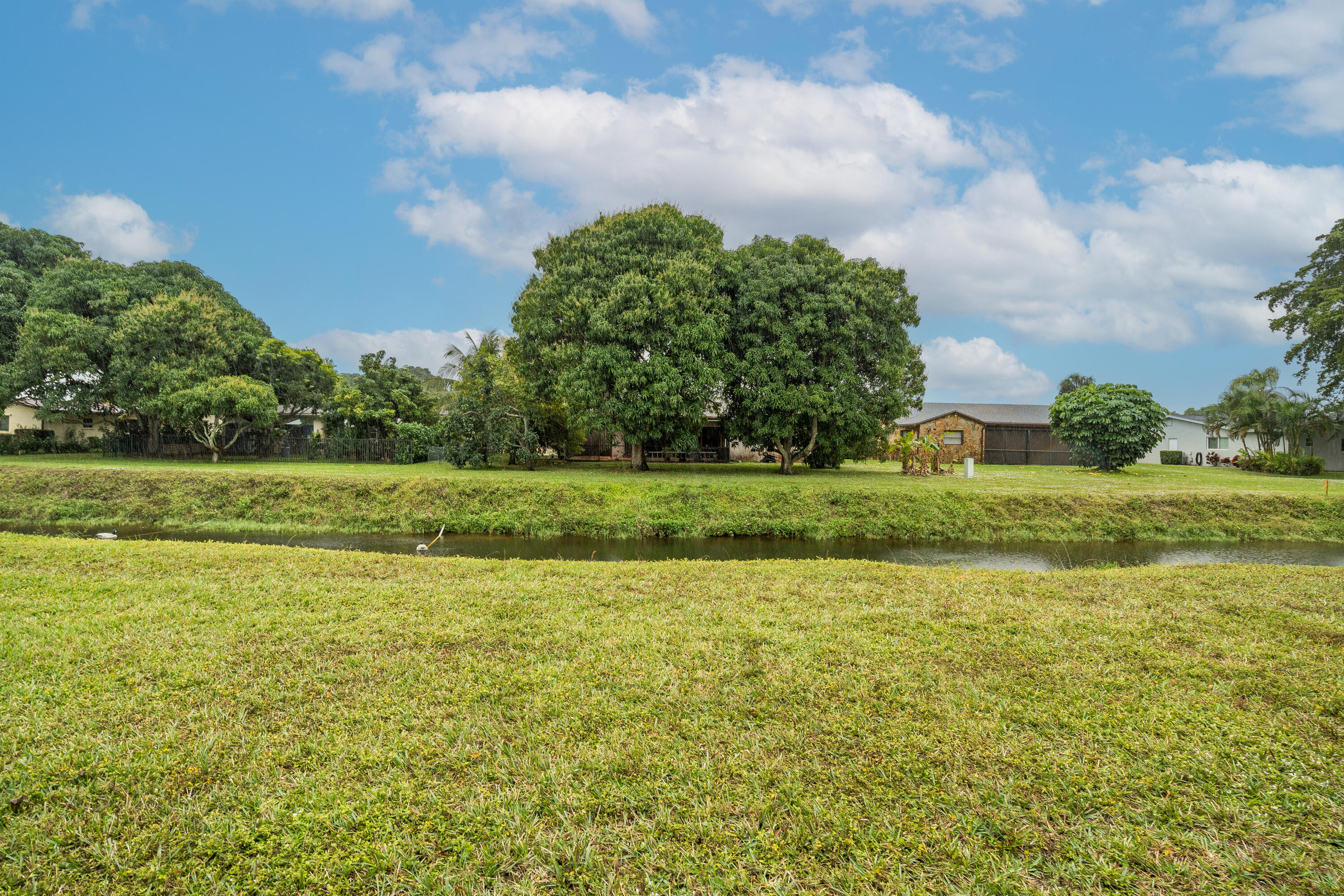 6220 Kings Gate Circle Delray Beach, FL 33484 - Photo 34 of 59 a view of a green field with wooden fence