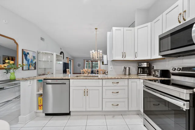 a kitchen with stainless steel appliances granite countertop a sink a stove and a refrigerator