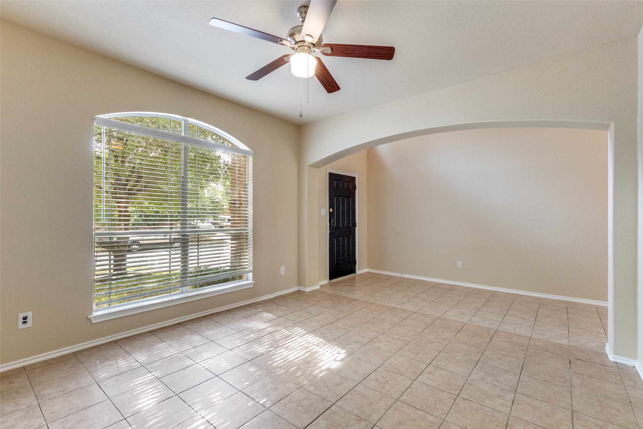 3816 Bandice Lane Pflugerville, TX 78660 - Photo 3 of 33 Living room featuring arched walkways, a ceiling fan, and light tile patterned flooring