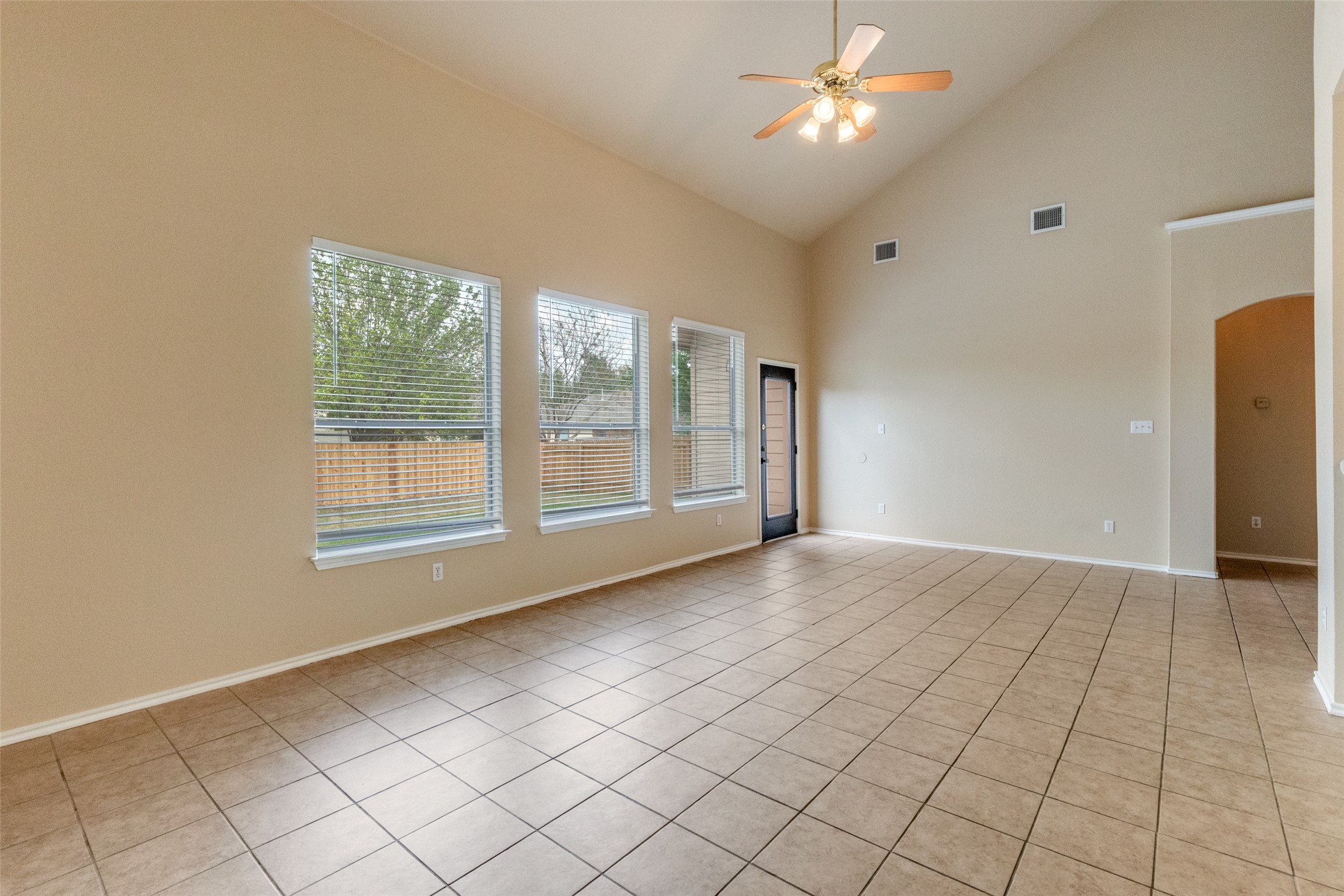 3816 Bandice Lane Pflugerville, TX 78660 - Photo 10 of 33 Family room featuring ceiling fan, arched walkways, lofted ceiling, and light tile patterned floors