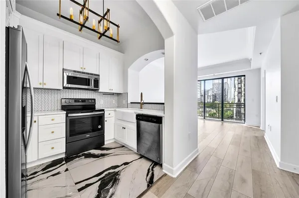 a kitchen with granite countertop a stove a sink and a refrigerator