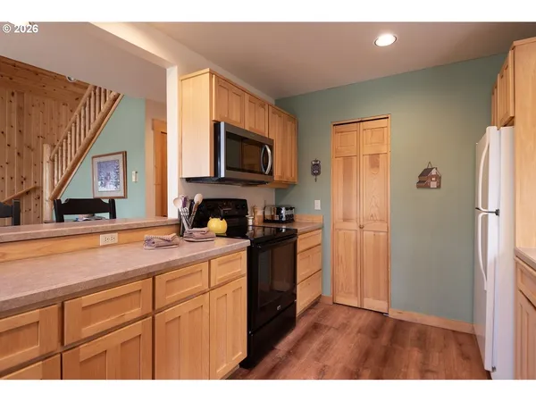 a kitchen with stainless steel appliances granite countertop a refrigerator a stove a sink and a microwave