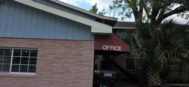 a front view of a house with a tree