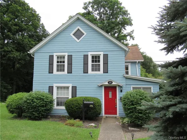 a front view of a house with a garden and plants