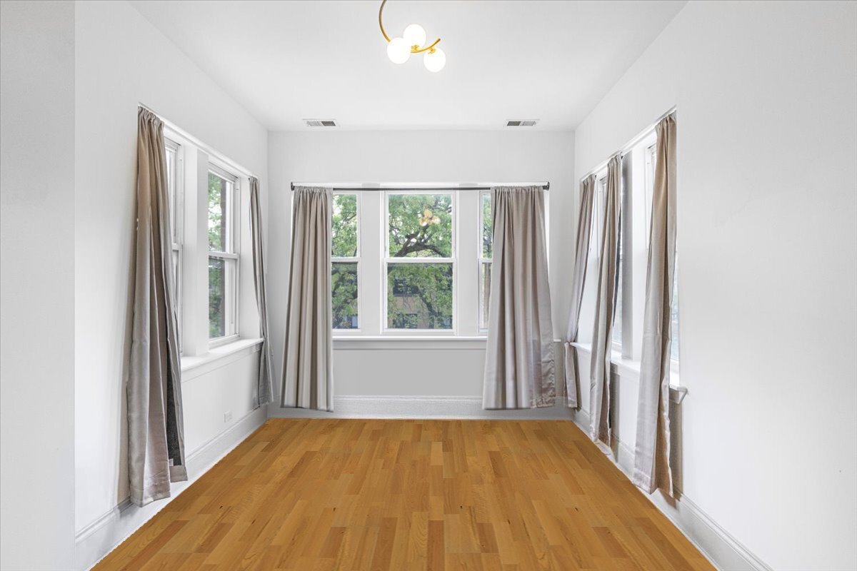 4855 North Springfield Avenue, Unit 3 Chicago, IL 60625 - Photo 5 of 9 a view of an empty room with wooden floor and a window