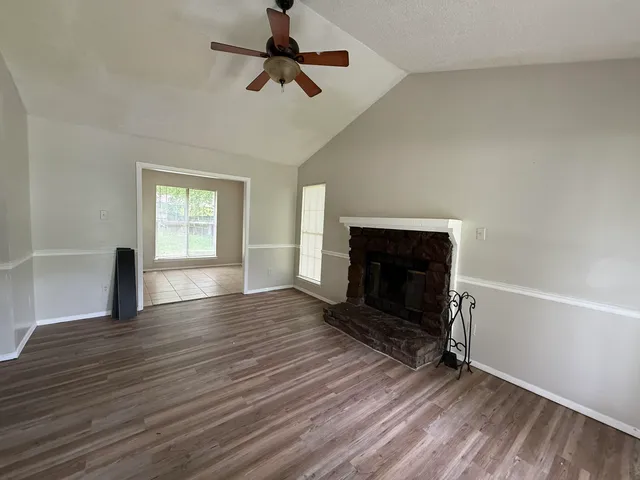 wooden floor fireplace and windows in an empty room