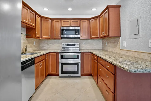 a kitchen with stainless steel appliances granite countertop a stove microwave and sink