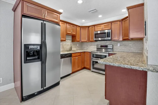 a view of a kitchen with a sink and a refrigerator
