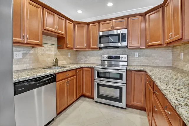 a bathroom with a granite countertop sink a toilet and a shower