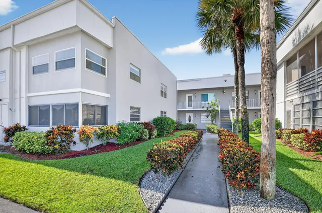 a front view of a multi story building with yard