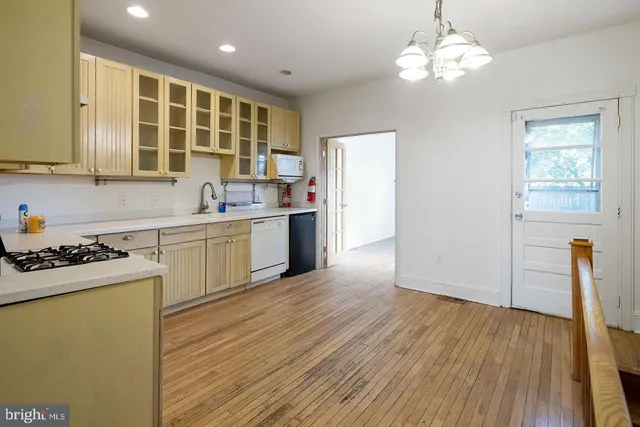 a kitchen with stainless steel appliances granite countertop a sink stove and wooden floor