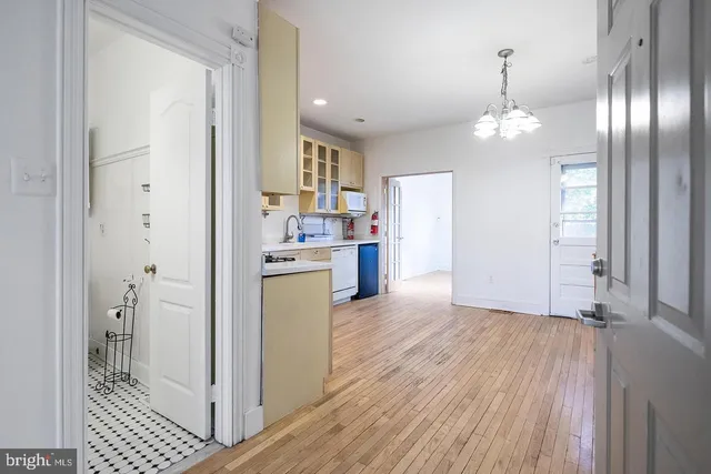 a view of a kitchen with a sink refrigerator and wooden floor