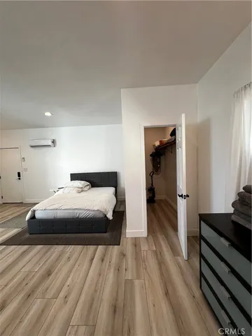 a bedroom with a bed and wooden floor